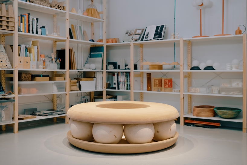 Bolas de madera ponen en movimiento un banco con forma de donut en un estudio junto al canal