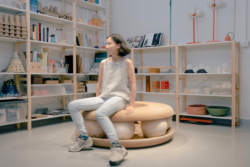 Bolas de madera ponen en movimiento un banco con forma de donut en un estudio junto al canal