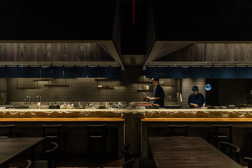 indigo fabric partitions float above sculpted concrete counters in rokusho bar by inrestudio