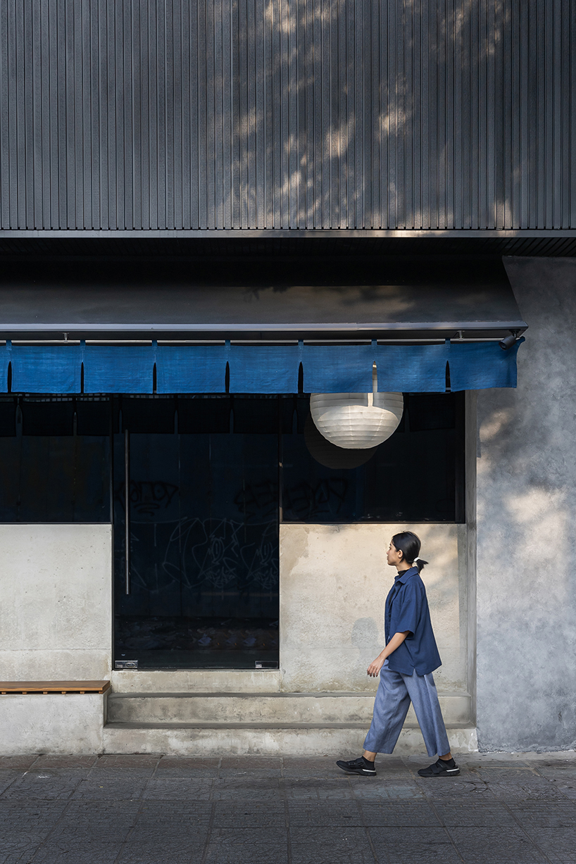 indigo fabric partitions float above sculpted concrete counters in rokusho bar by inrestudio