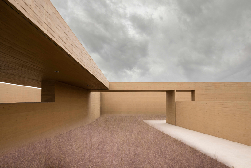 earth-toned concrete walls intertwine to form hot spring hotel by studio A+ in china