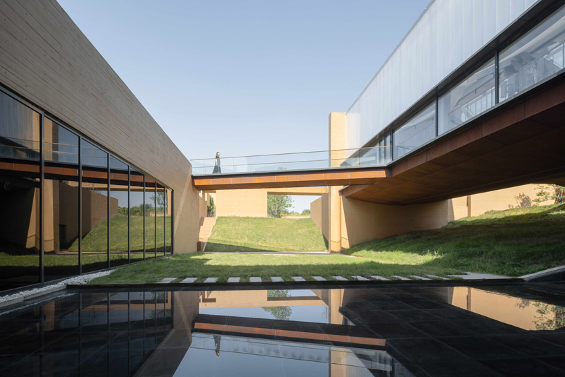 earth-toned concrete walls intertwine to form hot spring hotel by studio A+ in china