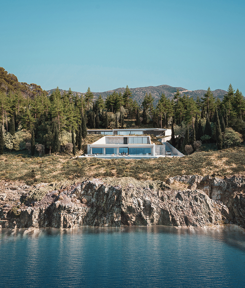 façade’s morphological villa is composed of white prisms wedged into the cliffs of lefkada