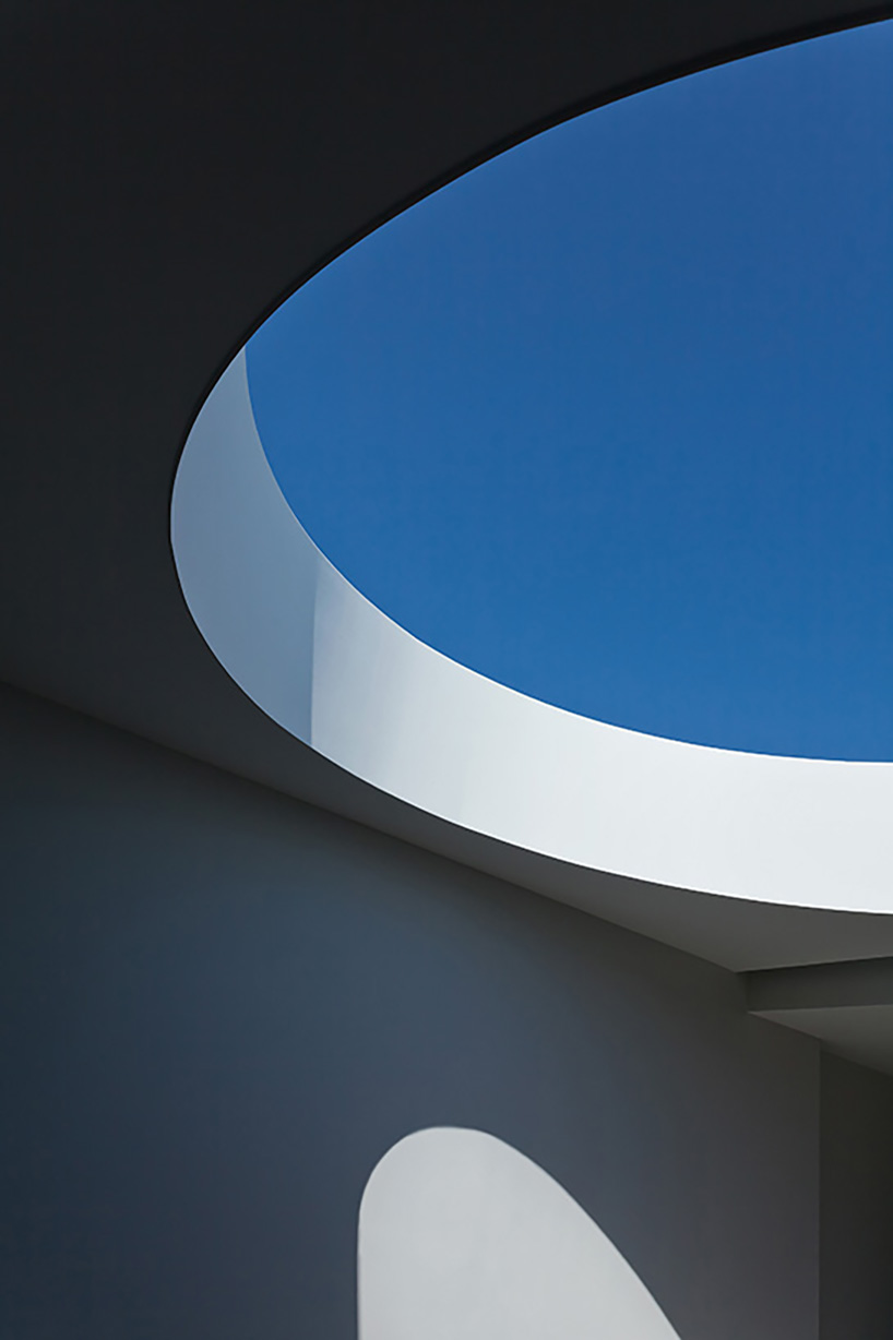 circular roof aperture sheds light through 'frame house' in greece