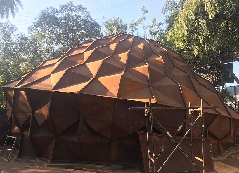 Metalowy namiot na zboczu wzgórza jako wielofunkcyjna przestrzeń imprezowa w Indiach