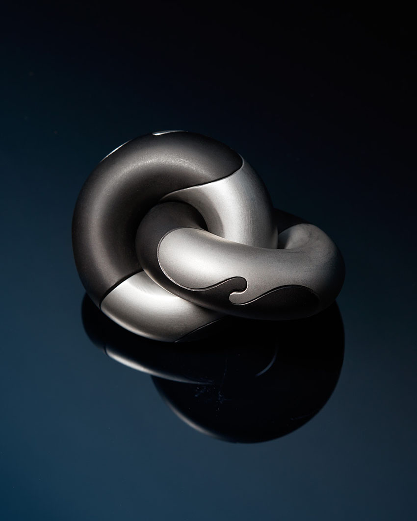 iridescent + matte black steel rings interlock to form mechanical ‘wavelinks puzzle’