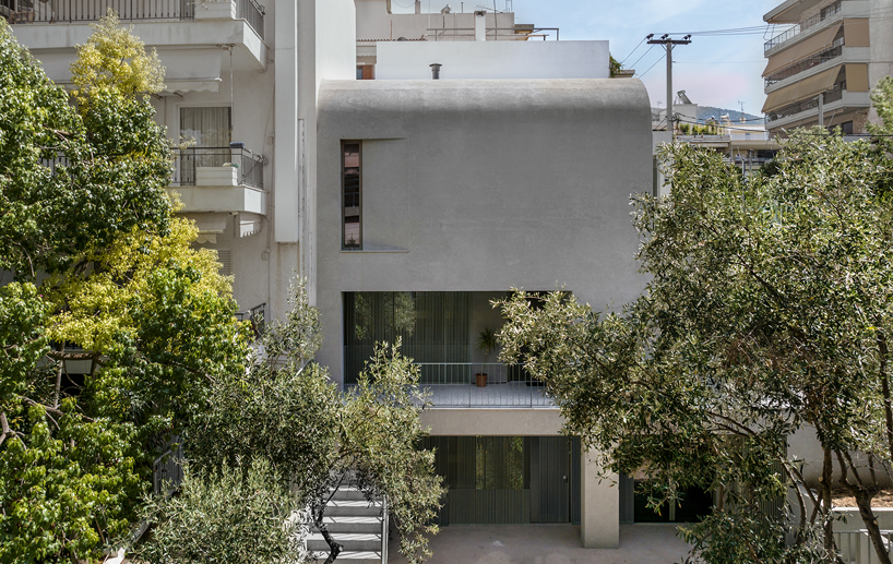 la façade en béton solide protège le jardin de la casa d de faible hauteur rénové à Athènes