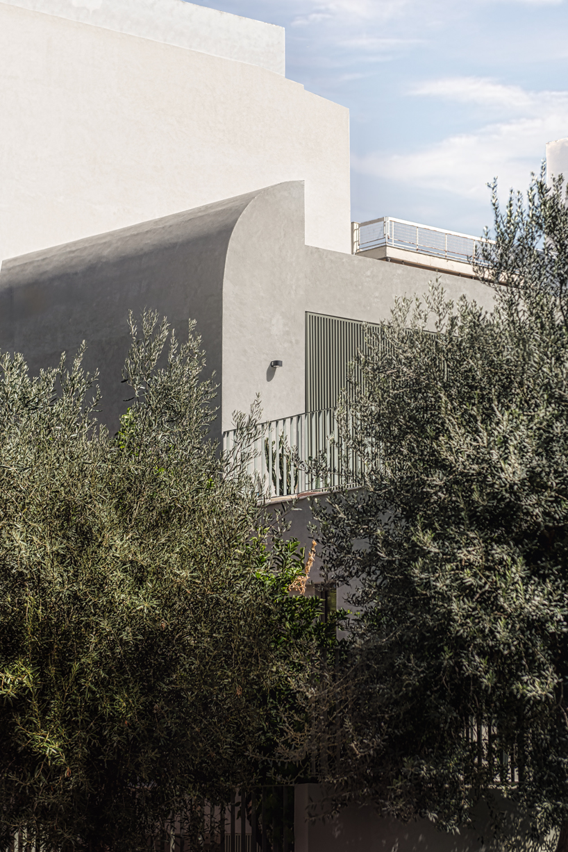 la façade en béton solide protège le jardin de la casa d de faible hauteur rénové à Athènes