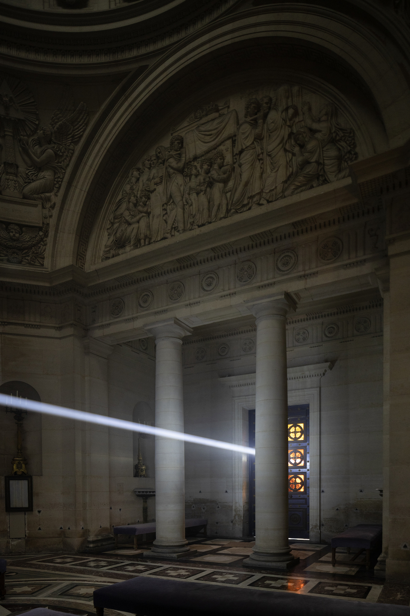 a beam of white light carves through paris' historical chapel - 9