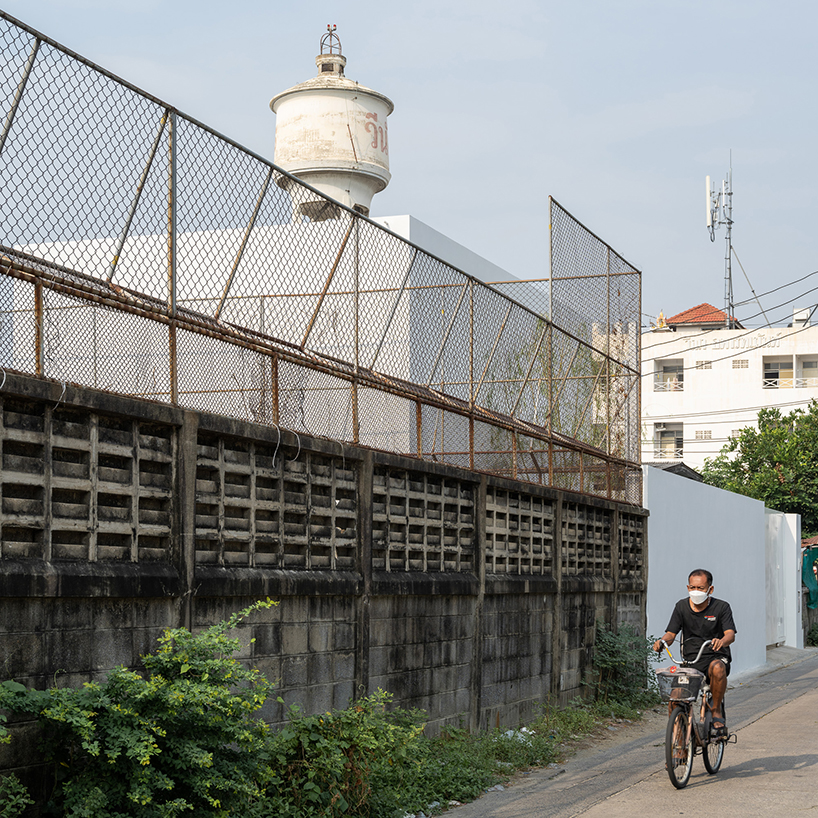 white dense geometric block pops out of urban bangkok neighborhood