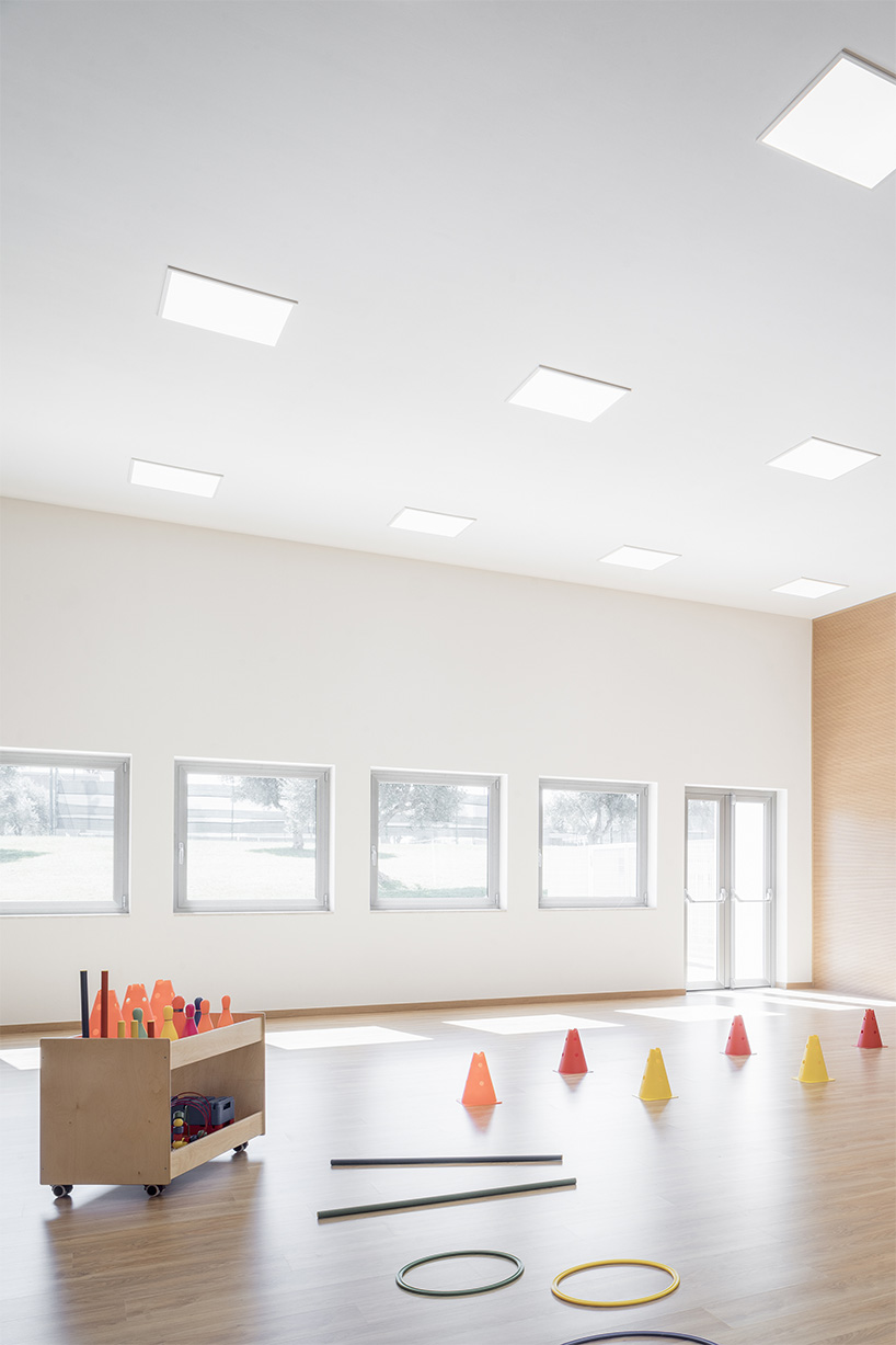 vibrant multipurpose room breathes new life into kindergarten in italy