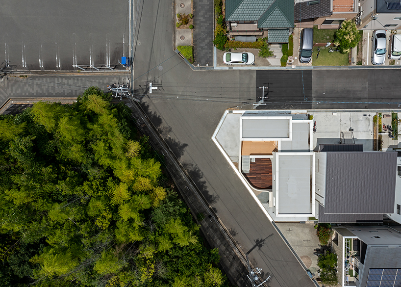 'spline' house's smooth curves frame forest backdrop in osaka