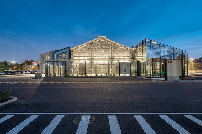 historic latvian cargo warehouse by sudraba arhitektura revived as cultural center, encased in glass and steel shell