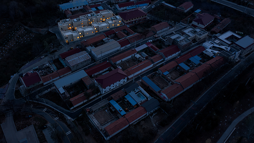eight interconnected stone-clad buildings compose long circle B&B in beijing