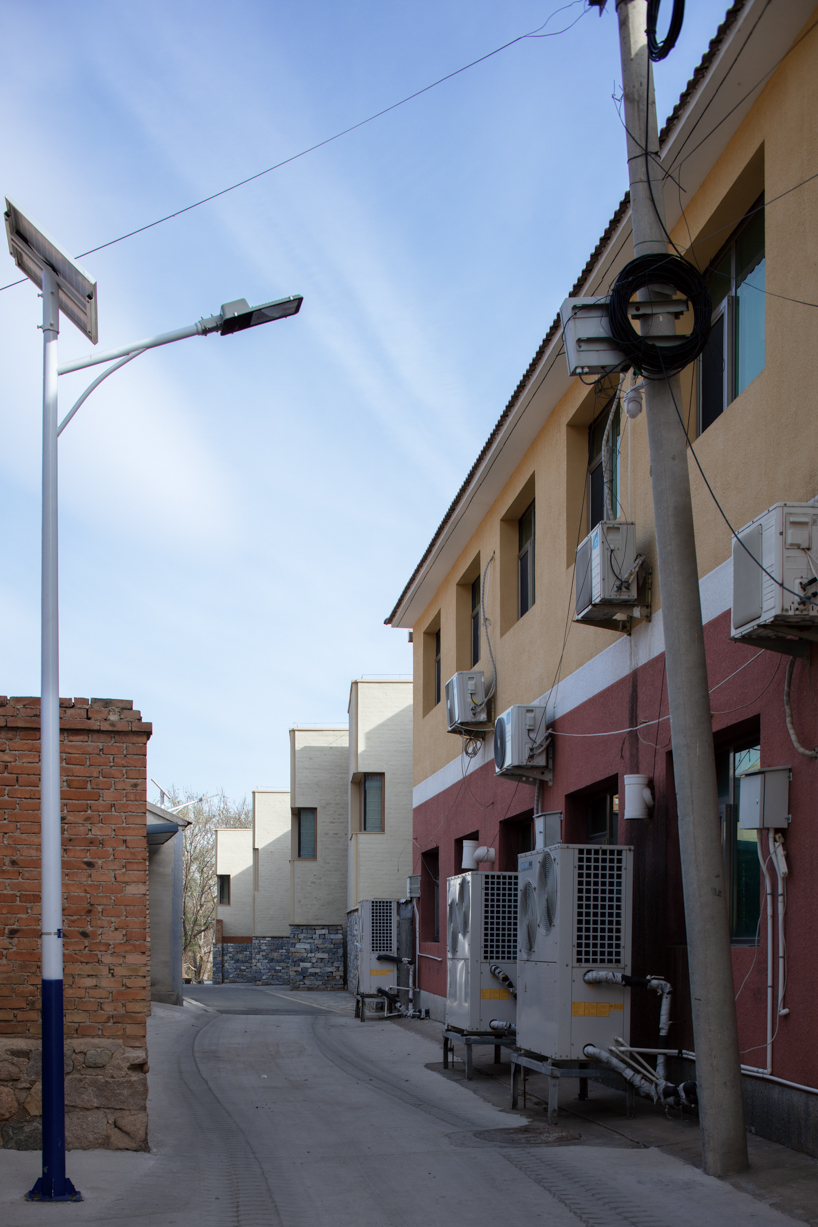 eight interconnected stone-clad buildings compose long circle B&B in beijing