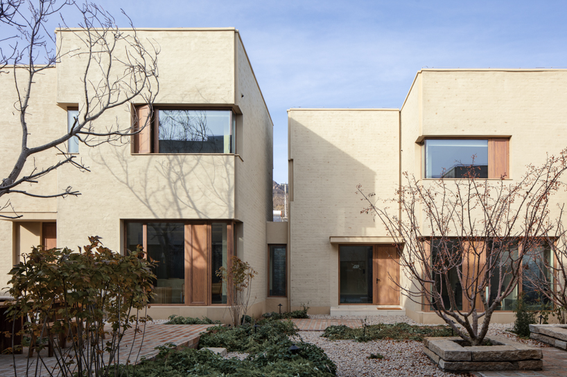 eight interconnected stone-clad buildings compose long circle B&B in beijing