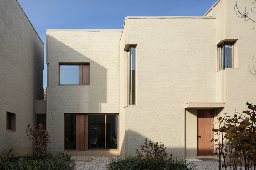 eight interconnected stone-clad buildings compose long circle B&B in beijing