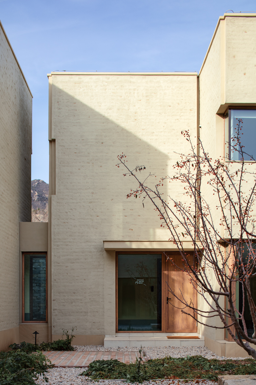 eight interconnected stone-clad buildings compose long circle B&B in beijing