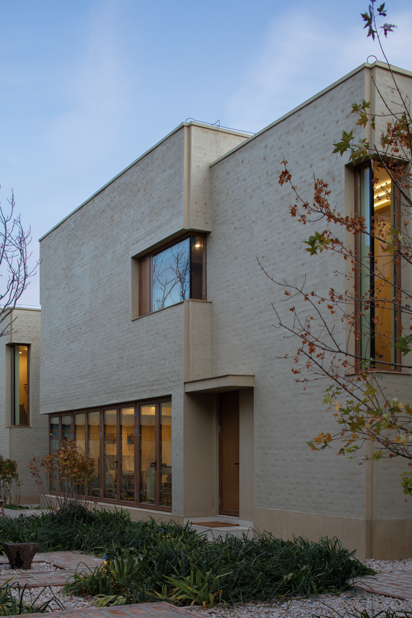 eight interconnected stone-clad buildings compose long circle B&B in beijing