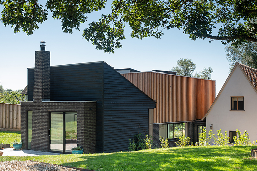 vertical oak cladded formation expands 17th-century renovated cottage in the UK