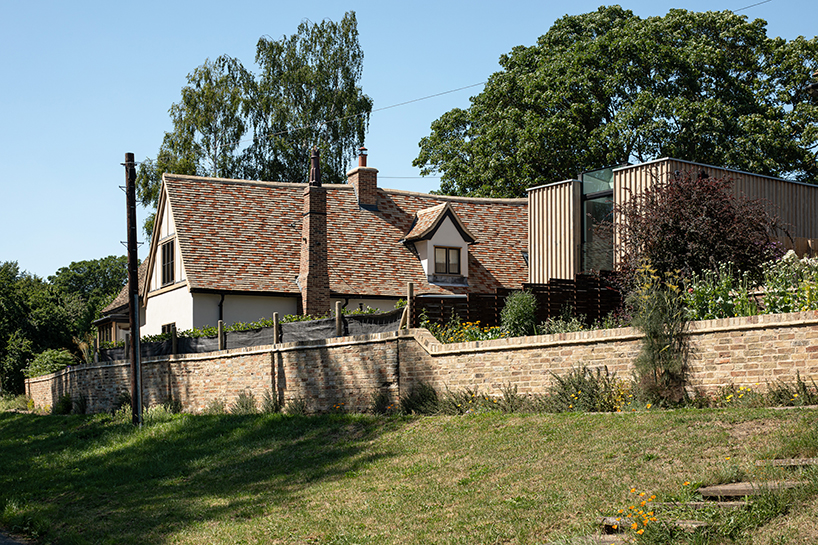 vertical oak cladded formation expands 17th-century renovated cottage in the UK
