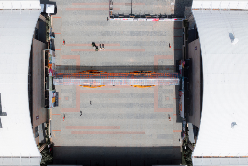 Un pabellón desnudo móvil forma un sinuoso puente de acero entre dos salas de exposiciones en la India