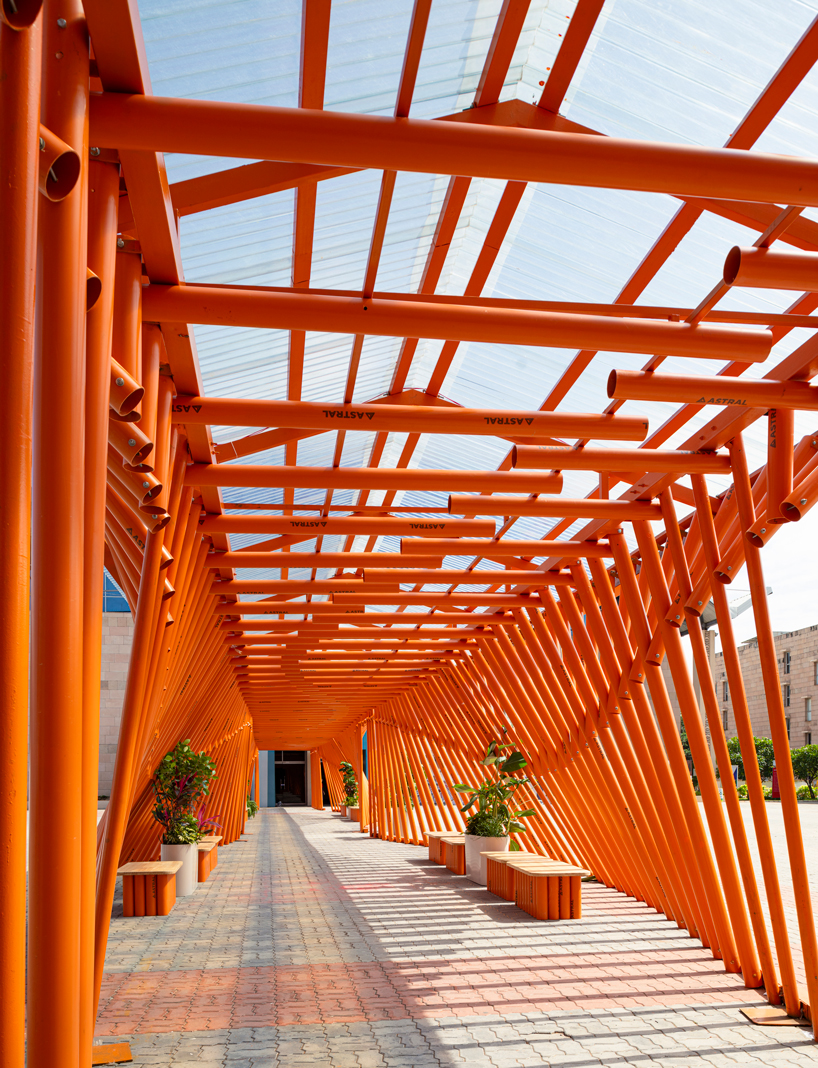 nudes' flow pavilion forms sinuous steel-pipe bridge between two exhibition halls in india