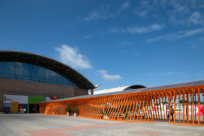 Un pabellón desnudo móvil forma un sinuoso puente de acero entre dos salas de exposiciones en la India