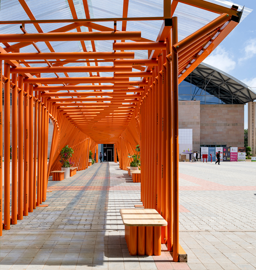 nudes' flow pavilion forms sinuous steel-pipe bridge between two exhibition halls in india