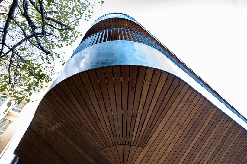 wavy wooden terraces overhang organically in residential neighborhood of japan