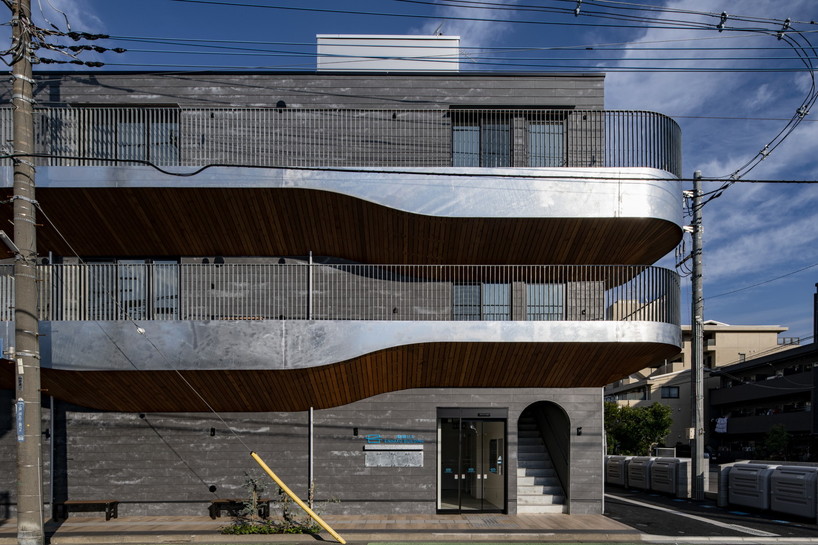 wavy wooden terraces overhang organically in residential neighborhood of japan