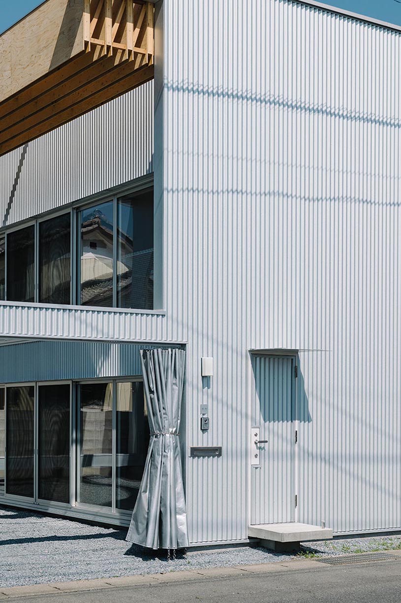 arched pergola loops over residential construction in japan covered in sheet metal