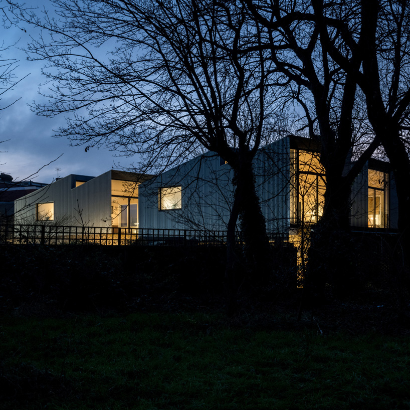 'upside-down' forest houses with sawtooth roofs rise from a brick plinth in london