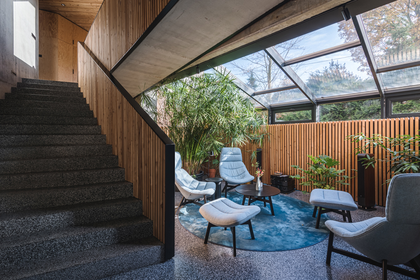 fragmented residence wraps in raw larch slats in polish countryside