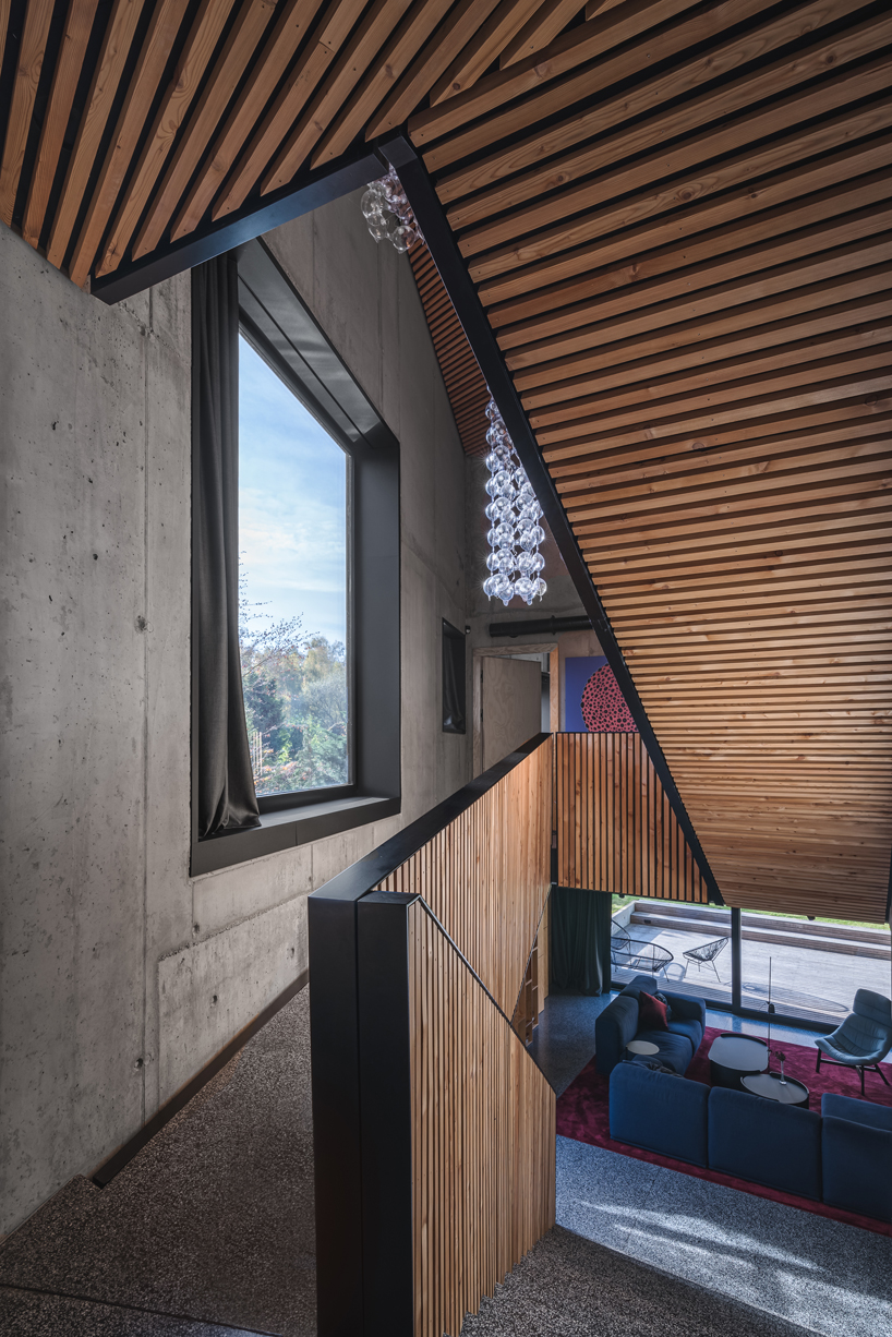 fragmented residence wraps in raw larch slats in polish countryside