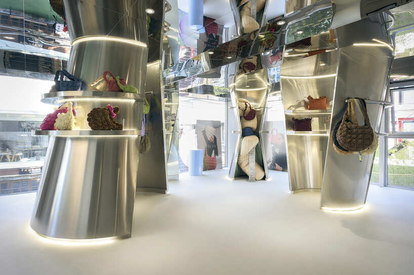 reflective steel coats carlyn showroom's fluid curved interiors in seoul