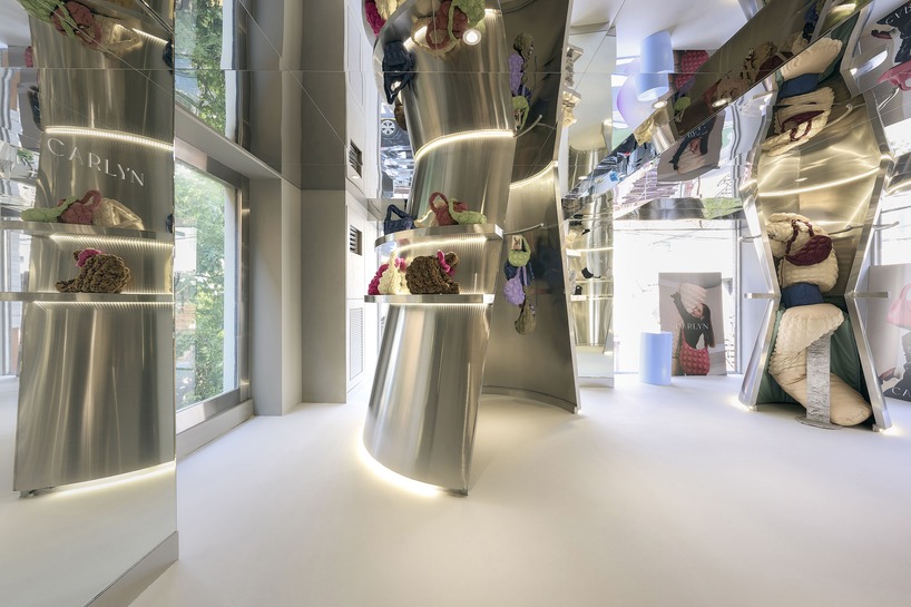 mirroring steel coats carlyn showroom's fluid curved interiors in seoul
