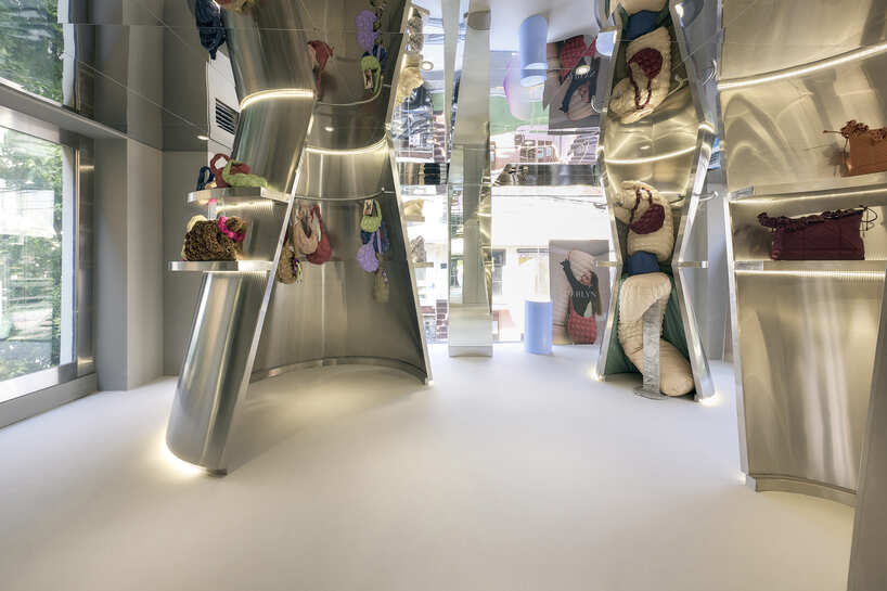reflective steel coats carlyn showroom's fluid curved interiors in seoul
