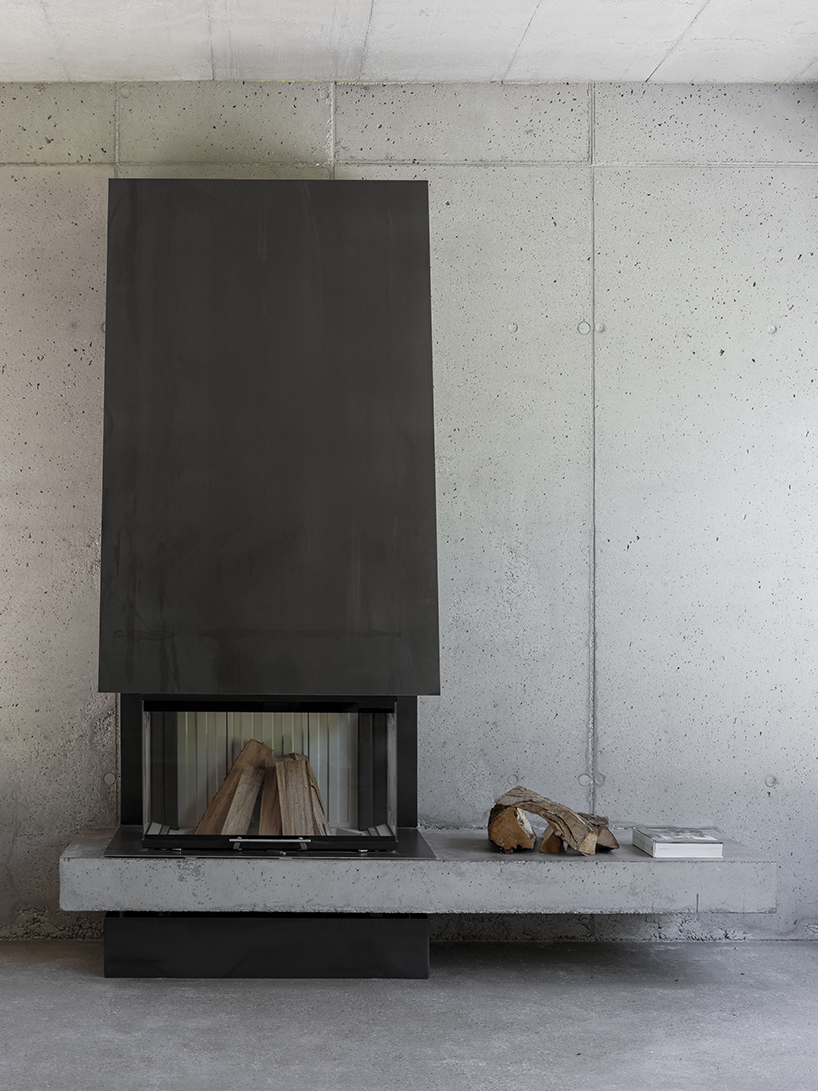 black charred timber cladding envelops twin gabled houses with one pillar in munich