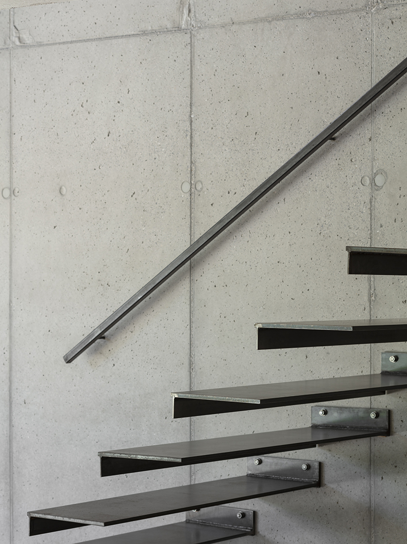 black charred timber cladding envelops twin gabled houses with one pillar in munich