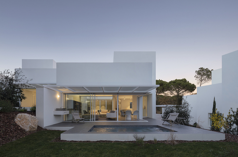 dozens of white cubes spread over a pine forest in the spanish countryside