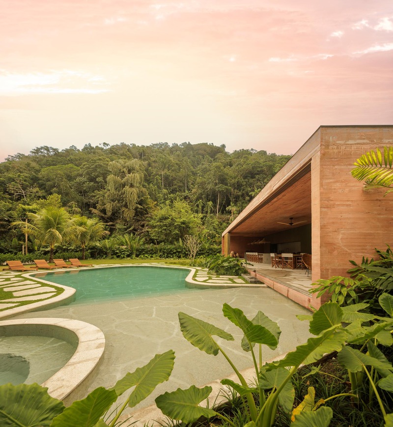 La casa de hormigón rosa seco de mf+arquitetos se destaca entre los frondosos bosques de Río de Janeiro