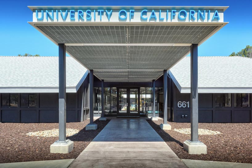 university research facility expands under floating asymmetrical pitched roof in california