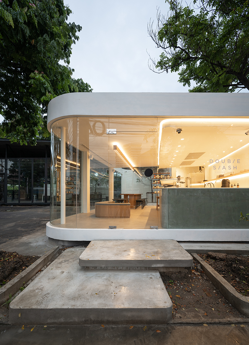 spacy architecture wraps serene bangkok cafe in floating glass