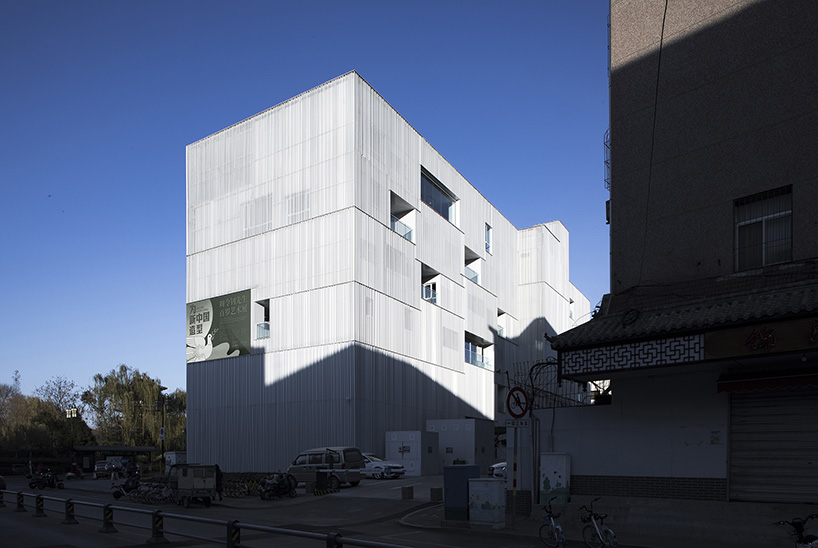 punched aluminum plates fold corrugated facade around TAOA's arts center in china