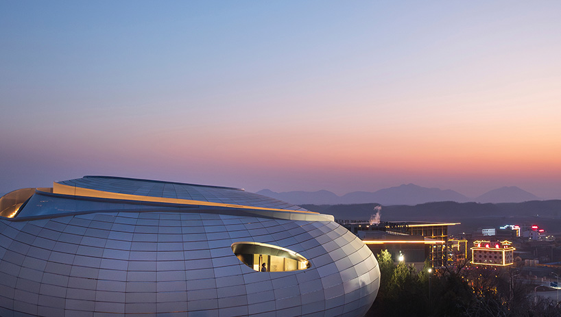wutopia lab carves soft white caving interiors for pebble-shaped mountain hotel in china