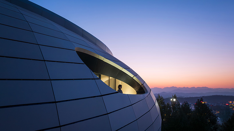 wutopia lab carves soft white caving interiors for pebble-shaped mountain hotel in china