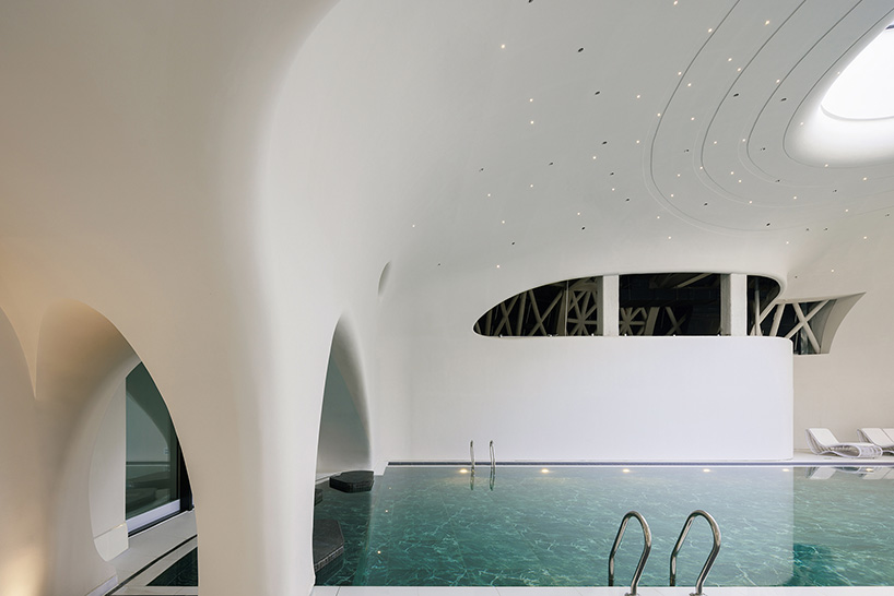 wutopia lab carves soft white caving interiors for pebble-shaped mountain hotel in china