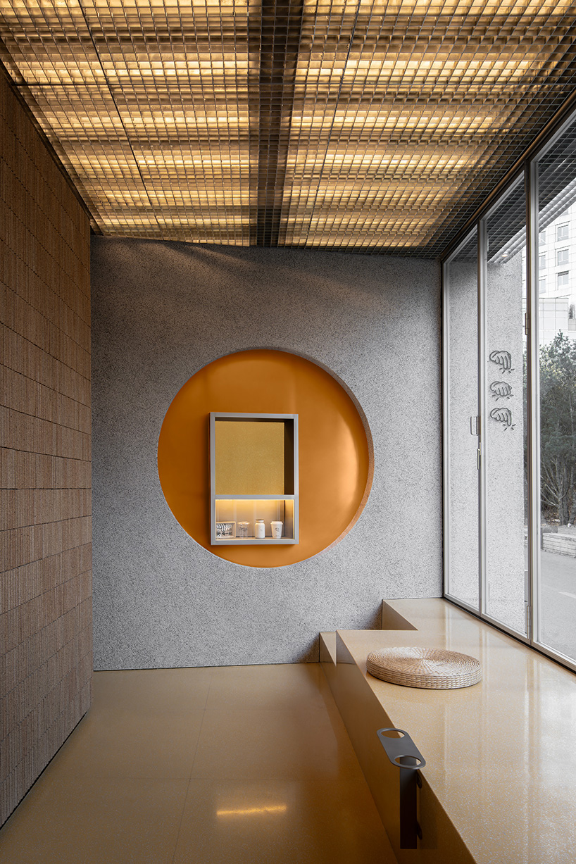 lantern-like lighting shines through suspended metal grid within tea pavilion in beijing