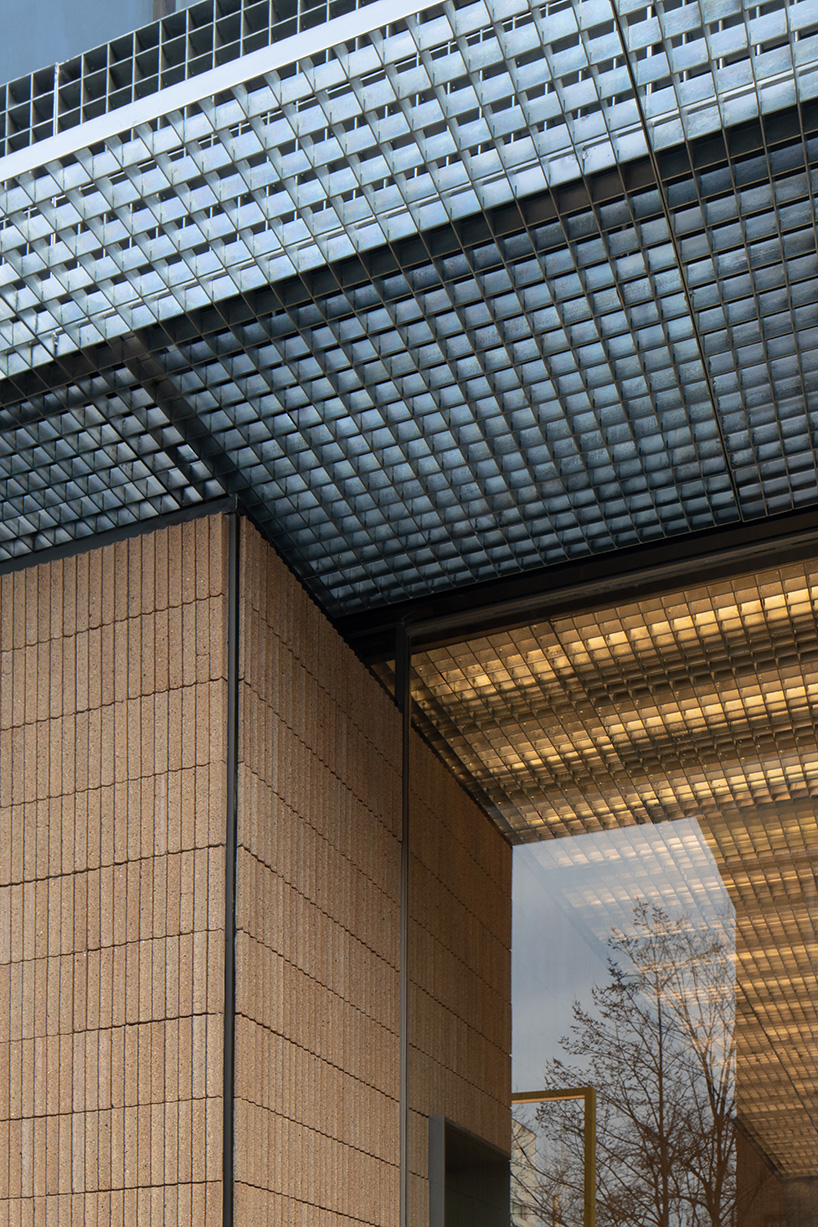 lantern-like lighting shines through suspended metal grid within tea pavilion in beijing